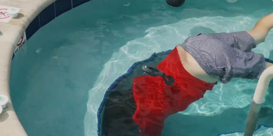 Diver using dye to test a pool fitting for leaks