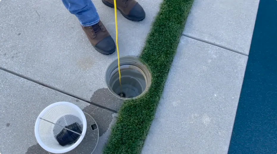 Technician lowering a listening device into a pool skimmer in Plant City